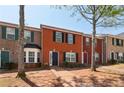 Brick townhouses with a mix of shutter colors, including black, red, and green, under a clear blue sky at 7712 Autry Circle # 204, Douglasville, GA 30134