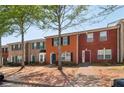Townhouse exteriors with brick facades, green and black shutters, and landscaped front yards on a sunny day at 7712 Autry Circle # 204, Douglasville, GA 30134