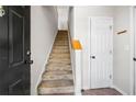 View of the carpeted staircase to the upper level next to a white door, providing access to the home's second floor at 603 Spring Heights Se Ln # 6, Smyrna, GA 30080