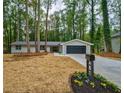 Charming renovated home with modern garage, front yard and fresh landscaping set among mature trees at 1329 Hidden Hills Pkwy, Stone Mountain, GA 30088