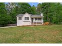 Well-maintained home with front porch, attractive siding, a lush lawn, and mature trees at 148 White Pine Ln, Temple, GA 30179