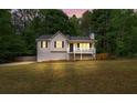 Inviting home with a front porch, neat landscaping, a lush lawn, and mature trees at 148 White Pine Ln, Temple, GA 30179