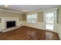 Living room showcasing a brick fireplace, hardwood floors, and ample natural light at 1960 Mceachern Manor Sw Dr, Marietta, GA 30064