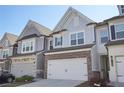 Charming townhome featuring brick and grey shingle facade, attached garage and well-maintained landscaping at 2946 Stockholm Way, Suwanee, GA 30024