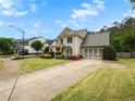 Lovely two-story home featuring an attached garage and long driveway surrounded by landscaped grounds at 135 Haleys Cir, Woodstock, GA 30188
