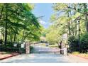 Stone gated entrance surrounded by lush trees, offering security and privacy to this charming neighborhood at 2007 Wingate Way, Atlanta, GA 30350