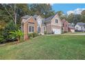 Lovely two-story home with stone details, a two-car garage, and lush green lawn at 3045 Wyntree Dr, Peachtree Corners, GA 30071