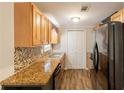 Functional kitchen featuring warm wood cabinetry, granite countertops, and modern black appliances at 110 Valley View Ct, Tyrone, GA 30290