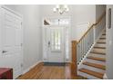 Bright and spacious foyer with hardwood floors, a staircase, and a modern chandelier, offering a grand entrance to the home at 123 Heritage Pointe, Woodstock, GA 30189