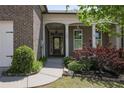 Inviting front porch with brick columns and manicured landscaping at 123 Heritage Pointe, Woodstock, GA 30189