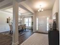 Elegant entryway with beautiful hardwood floors leading into the dining room with a large window at 259 Eason Ave, Bowdon, GA 30108