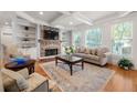 Inviting living room with stone fireplace, built-in shelving, hardwood floors and abundant natural light at 2823 Seagrave Way, Marietta, GA 30066