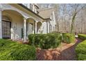 Charming brick pathway and manicured hedges lead to the welcoming front porch of this elegant home at 5120 Post Oak Tritt Ne Rd, Roswell, GA 30075