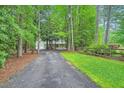 Long gravel driveway lined with trees and green foliage, leading to a beautiful home at 2010 Univeter Rd, Canton, GA 30115