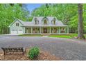 Inviting two-story home featuring a wide front porch with rocking chairs and swing at 2010 Univeter Rd, Canton, GA 30115