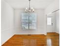Dining room with hardwood floors, a modern chandelier, and ample natural light at 2620 Nesbitt Crossing Way, Duluth, GA 30096