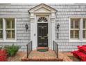 Elegant front entrance featuring a black door with a decorative transom and sidelights, flanked by classic sconces at 452 Cherokee Ne St, Marietta, GA 30060