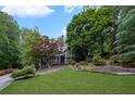 Lush front lawn and landscaping surround this home, featuring mature trees and colorful plantings at 2310 Piedmont Forest Dr, Marietta, GA 30062