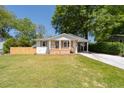 Inviting renovated home with a classic white exterior, wooden porch, and a well-manicured lawn at 1045 Ridgecrest Se Dr, Smyrna, GA 30080