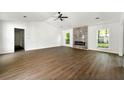 Spacious living room with modern fireplace, ceiling fan, and hardwood floors at 2254 Lisbon Ln, Jonesboro, GA 30236