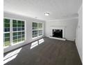 Spacious living room featuring a fireplace, large windows, and plush carpeting at 4269 David Austin Ct, Snellville, GA 30039