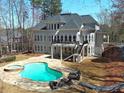 Enjoy the outdoors in this amazing backyard with a sparkling pool, spa, and comfortable seating area at 621 Champions Dr, Mcdonough, GA 30253