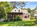Backyard with a screened porch, a brick patio, and mature trees offering shade at 1919 Edinburgh Ne Ter, Atlanta, GA 30307