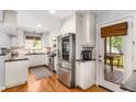 Modern kitchen featuring stainless steel appliances, white cabinets, granite countertops, and hardwood floors at 1919 Edinburgh Ne Ter, Atlanta, GA 30307