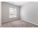 Neutral bedroom with plush carpet, bright window, and fresh paint, creating a serene atmosphere at 6757 Delaware Bnd, Fairburn, GA 30213