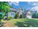 Beautiful single-Gathering home featuring lush green lawn, mature trees, and a well-maintained facade at 6757 Delaware Bnd, Fairburn, GA 30213