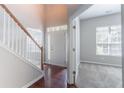 Inviting foyer with hardwood floors, staircase, and plenty of natural light streaming through the front door at 6757 Delaware Bnd, Fairburn, GA 30213