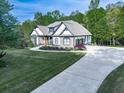 Beautiful home featuring a long driveway, three-car garage, manicured lawn, and tasteful landscaping at 1076 Pinyan Ln, Canton, GA 30115