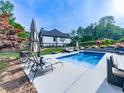 Inviting backyard pool with lounge chairs, patio furniture, and lush landscaping at 1076 Pinyan Ln, Canton, GA 30115