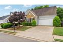 Well-maintained home with a two-car garage, landscaped lawn, and a mix of stone and siding at 3911 Delfaire Trce, Cumming, GA 30040