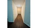 View of a home hallway with hardwood floors and neutral colored walls leading to the front door at 6905 Rogers Pt, Lithonia, GA 30058