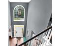 Bright foyer featuring hardwood floors, a large window, and elegant staircase at 92 Creek Front Way, Lawrenceville, GA 30043