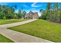 Long driveway leading up to a beautifully landscaped new construction home at 7474 Waterview Cv, Douglasville, GA 30135