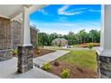 View of the home from the front porch featuring stone pillars and landscaping at 7474 Waterview Cv, Douglasville, GA 30135