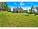 A well-manicured lawn leads up to a new construction house under a bright blue sky at 7474 Waterview Cv, Douglasville, GA 30135