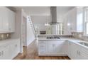 Bright kitchen featuring white cabinets, stainless appliances, and hardwood flooring at 1209 Fenmore Hall Dr, Powder Springs, GA 30127