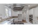 Modern kitchen with stainless steel appliances, white cabinetry, and a glass range hood at 1209 Fenmore Hall Dr, Powder Springs, GA 30127