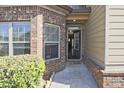 Inviting entryway with a brick facade, a 'hello' mat, and natural light streaming through the windows at 3877 Valley Bluff Ln, Snellville, GA 30039