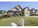A picturesque view of a beautifully landscaped front yard with green grass and lovely shrubs at 3877 Valley Bluff Ln, Snellville, GA 30039