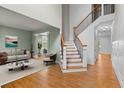 Bright entryway offers gorgeous hardwood floors, a staircase with wooden rails, and open access to the living room at 5106 Davis Love Dr, Cumming, GA 30041