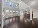 Open-concept living room featuring high ceilings, large windows, and hardwood floors at 2470 Bridle Bridge Trl, Cumming, GA 30040