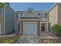 Townhome exterior with manicured lawn and attached garages at 384 Parc River Blvd, Lawrenceville, GA 30046