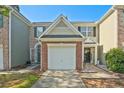 Charming townhome with single car garage, brick accents, and well-maintained landscaping at 384 Parc River Blvd, Lawrenceville, GA 30046