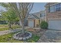 Inviting townhome boasts a one-car garage, well-maintained lawn, and landscaped tree bed at 384 Parc River Blvd, Lawrenceville, GA 30046