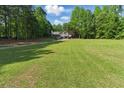 Sprawling lawn and a picturesque view of the home nestled among mature trees at 655 Poplar Rd, Dallas, GA 30157