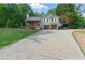 Well-maintained home with a long driveway and a large lawn in a wooded setting at 655 Poplar Rd, Dallas, GA 30157